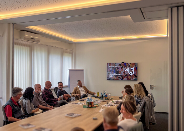 Fellhof-Jahresmeeting: Mitarbeitende sitzen am Tisch des Besprechungsraums
